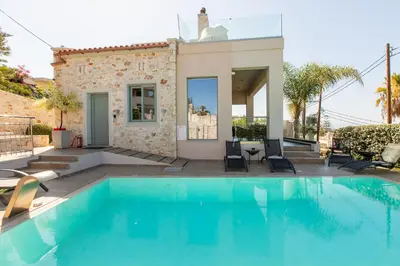 a swimming pool in front of a house at Superior Villa Kleanthi in Stalos