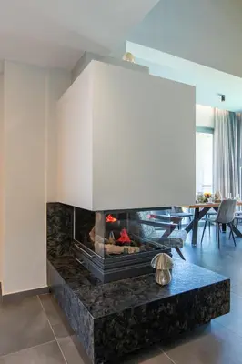 a fireplace in a living room with a table at Superior Villa Kleanthi in Stalos