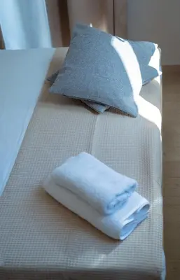 a bed with two towels and two pillows on it at Mare I - studio in Old Harbor in Chania Town