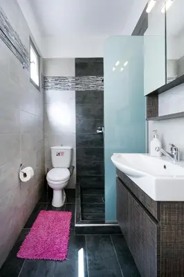 a bathroom with a sink and a toilet with a pink rug at Mare I - studio in Old Harbor in Chania Town