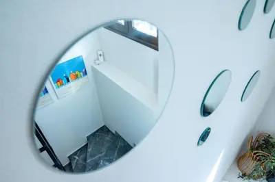 a circular mirror reflecting a staircase in a room at Mare II - Studio in Old Harbor in Chania Town