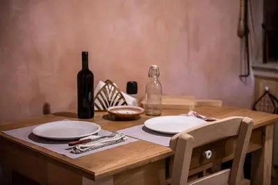 a wooden table with two plates and a bottle of wine at Lemon Tree Eco-Retreat in Gavalochori