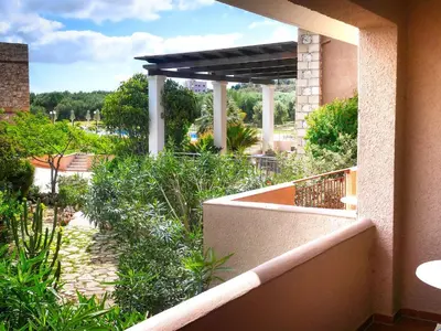 a balcony of a building with a view of a garden at Areti Aparthotel in Áptera