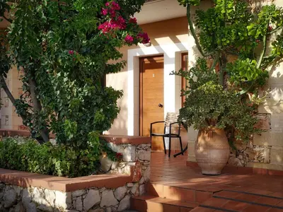 a porch with two large vases filled with flowers at Areti Aparthotel in Áptera