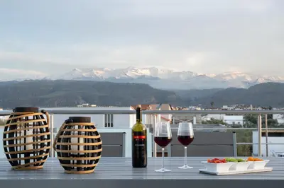 a table with two glasses of wine and a plate of food at Amaen Apartment in Chania Town