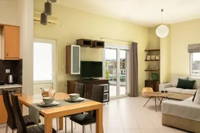 a kitchen and living room with a table and a couch at Amaen Apartment in Chania Town