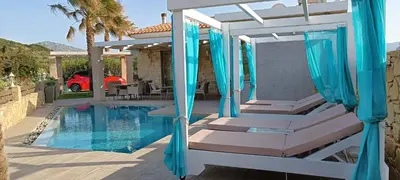 a swimming pool with a pergola and chairs next to a house at Elena Villa in Kissamos