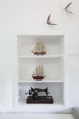a shelf with three ships and a sewing machine at Monastery Estate Guesthouse in Sougia