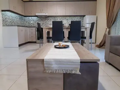 a kitchen with a wooden table and chairs at Anatoli View in Agia Marina Nea Kydonias