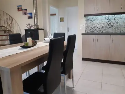 a kitchen with a wooden table and black chairs at Anatoli View in Agia Marina Nea Kydonias