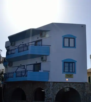 a white building with blue balconies on it at Galini Studios in Palaiochóra