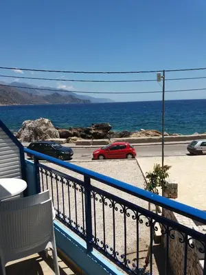 a red car parked on a balcony overlooking the ocean at Galini Studios in Palaiochóra