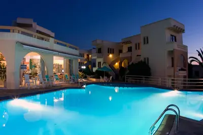 a swimming pool in a resort at night at Olga Suites in Maleme