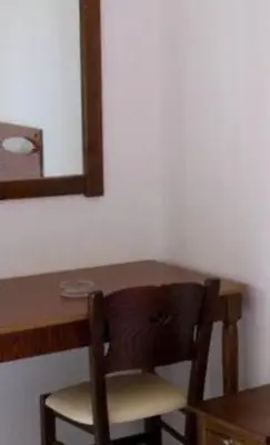 a wooden table with a chair and a mirror at Oasis Studios in Palaiochóra