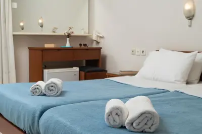 a hotel room with a bed with towels on it at Hotel Haris on the beach in Agia Marina Nea Kydonias