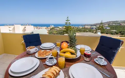 a table with breakfast food on a balcony with a view at Casa di Halepa in Chania Town