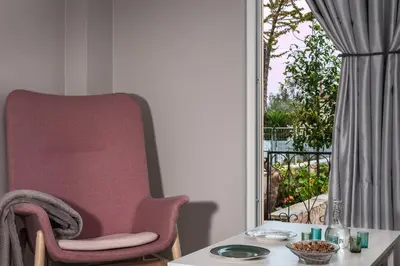 a room with a chair and a table and a window at Thea Artemis in Kato Daratso