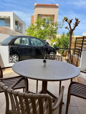 a table and chairs with a car in a parking lot at Thea Artemis in Kato Daratso