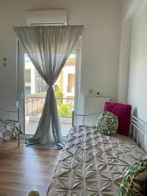 a bedroom with a bed and a large window at Thea Artemis in Kato Daratso