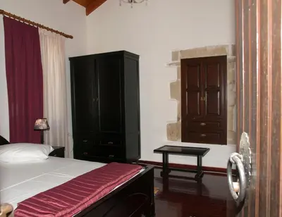 a bedroom with a bed and a wooden cabinet at Villa Eternity in Alikampos