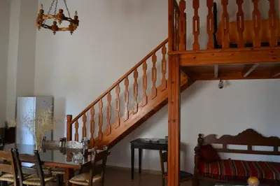 a wooden staircase in a room with a table and a chair at Villa Eternity in Alikampos