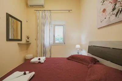 a bedroom with a red bed and a window at Spacious Home with Parking in Chania Town