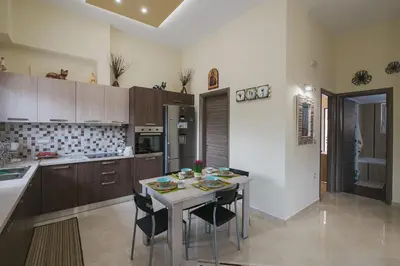 a kitchen with a table and chairs in a kitchen at Spacious Home with Parking in Chania Town