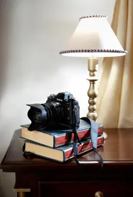 a camera sitting on a stack of books next to a lamp at Casa Perla Suites in Chania Town