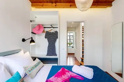 a bedroom with a bed with colorful pillows on it at La Barchetta Old Town Home with Seaview in Chania Town