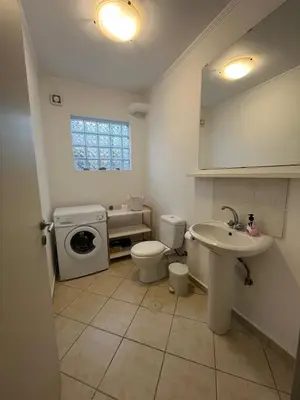 a bathroom with a toilet sink and a washing machine at Stay Salty - Two Different Houses in Marathi