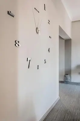 a room with a white wall with clocks on it at Sophia's Castle View Apartment in Chania Town