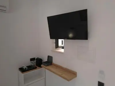 a flat screen tv hanging on a white wall at Antica Canea Luxury Rooms in Chania Town