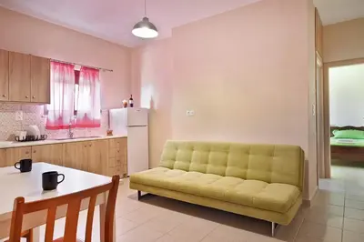 a living room with a yellow couch in a kitchen at Sfakia Thea Apartments in Sfakiá