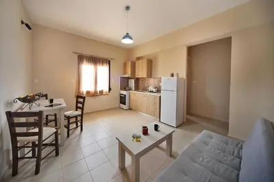 a living room with a couch and a table and a kitchen at Sfakia Thea Apartments in Sfakiá