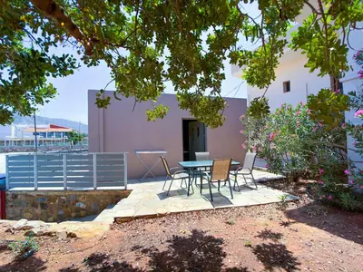 a patio with a table and chairs in front of a building at Elafonisi Paradise with Parking, WiFi, - Walking Distance to the Beach in Elafonisi