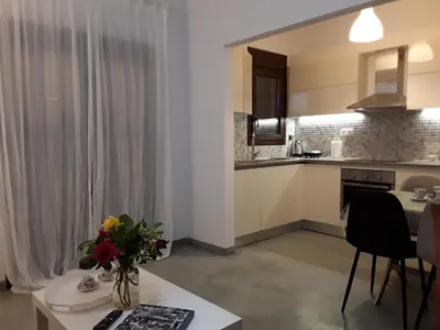 a kitchen with a table with a vase of flowers on it at Waves House in Kissamos