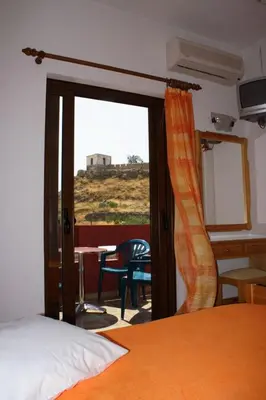 a bedroom with a bed and a sliding glass door at Kochyli Studios in Palaiochóra