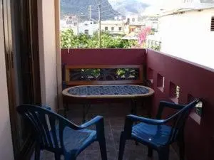 a balcony with two chairs and a table and a window at Kochyli Studios in Palaiochóra