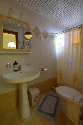 a bathroom with a sink and a toilet and a shower at Kochyli Studios in Palaiochóra