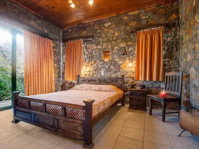 a bedroom with a bed and a stone wall at Villa Livadia with Pool, close to Elafonissi famous Beach in Livadia