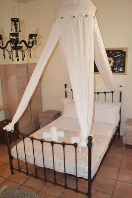 a bedroom with a canopy bed with white curtains at Yro Studios in Chania Town