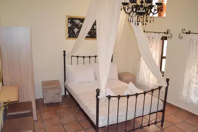 a bedroom with a canopy bed with a chandelier at Yro Studios in Chania Town