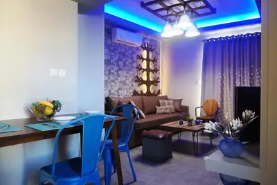 a living room with a couch and a table and chairs at Seas the view in Chania Town