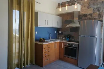 a kitchen with a white refrigerator and wooden cabinets at Seas the view in Chania Town