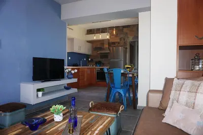 a living room with a table and a kitchen at Seas the view in Chania Town
