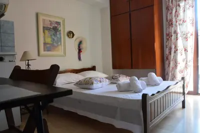 a bedroom with a bed with white sheets and pillows at Poseidon Studios Chania Center in Chania Town