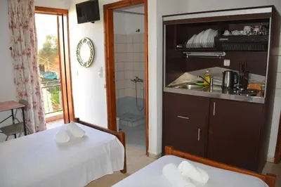 a small room with two beds and a bathroom at Poseidon Studios Chania Center in Chania Town