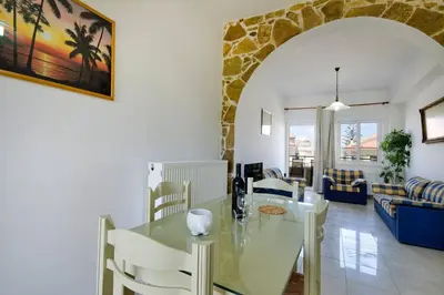 a dining room and living room with a table and chairs at Despina Villa in Agia Marina Nea Kydonias