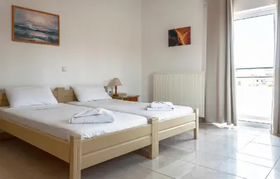 a bedroom with two beds and a window at Despina Villa in Agia Marina Nea Kydonias