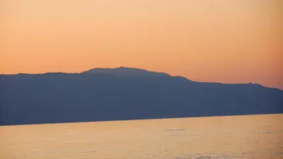 a view of a mountain from the ocean at sunset at Despina Villa in Agia Marina Nea Kydonias
